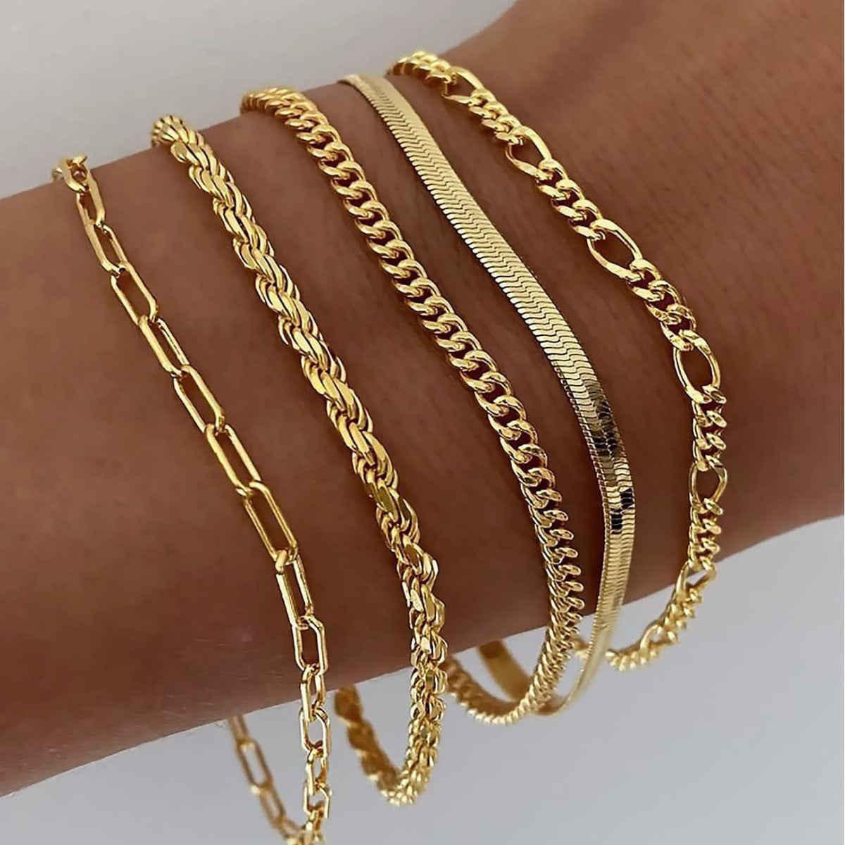 Layered gold bracelets worn on the wrist